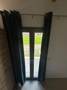 una puerta de cristal con cortinas negras en una habitación en Ktimavita Apartment 2, en Petra