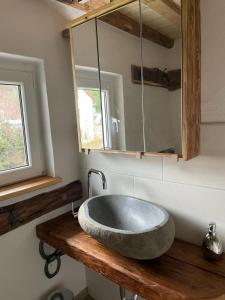 a bathroom with a large stone sink on a wooden counter at Ferienhaus Linde in Warmensteinach