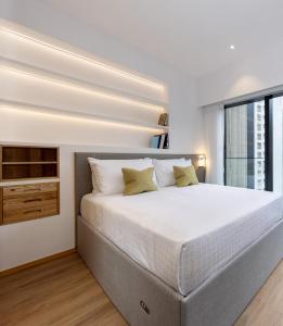 een witte slaapkamer met een groot bed en een raam bij Shama Hub Metro South Hong Kong in Hong Kong