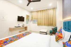 FabHotel Hari Kunj في فاراناسي: غرفة نوم فيها سرير وتلفزيون