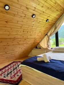 sypialnia z łóżkiem i drewnianym sufitem w obiekcie Borjomi inn Cottages w Bordżomi