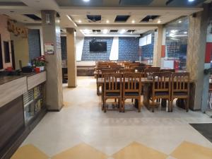 una sala da pranzo con tavolo e sedie di Hotel natraj pachmarhi a Pachmarhī