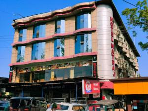 un grande edificio con macchine parcheggiate di fronte di Hotel natraj pachmarhi a Pachmarhī