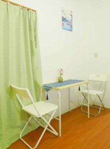 biurko i 2 krzesła w pokoju ze stołem w obiekcie TOKYOSTYLE w Tokio