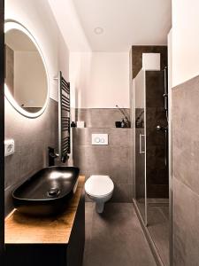 a bathroom with a black bath tub next to a toilet at Si-View Einzelzimmer mit Balkon Zimmer 6 in Siegen