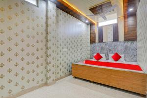 een slaapkamer met een bed met rode kussens erop bij A5 Hotel And Dormitory in Gorakhpur