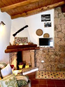 a living room with a stone fireplace with a television at Le Verande di Isola Rossa in Isola Rossa