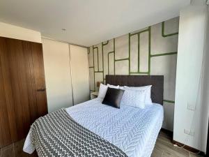 a bedroom with a large bed with a white comforter at Cozy apartment near Airport in Guatemala