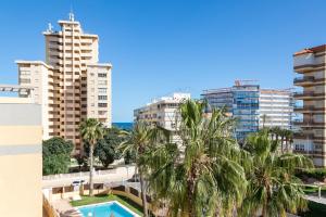 - une vue depuis le balcon d'un bâtiment avec des palmiers et des bâtiments dans l'établissement Juan de la Cierva Playa, à El Campello