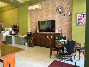 a living room with a tv on a brick wall at 花蓮夜市民宿-有洗烘衣機-可停重機 in Hualien City