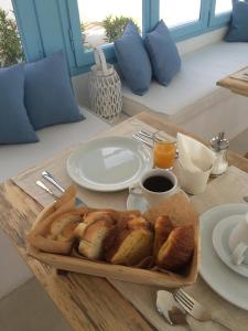 a table with a tray of bread and coffee on it at Villa Maria Rooms in Akrotiri