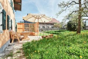 a picnic table with an umbrella in a yard at Beim Sattler in Peiting