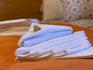 a pile of towels sitting on top of a bed at Nimfa Apartments in Păuleni-Ciuc