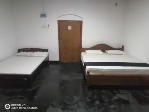 a room with two beds and a door at Walawwa resort in Kurunegala