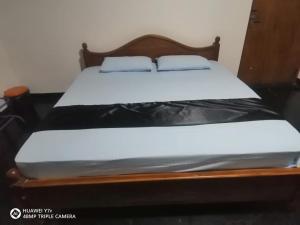 uma cama com uma moldura de madeira com um colchão em Walawwa resort em Kurunegala