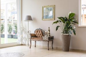 a room with a chair and a potted plant at Hotel La Perla in Cervia