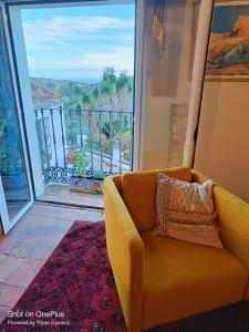 a yellow couch in a room with a large window at Beautiful House with Sea View and Nature, 30 minutes from Malaga in Moclinejo