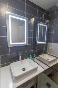 La salle de bains est pourvue d'un lavabo et de deux miroirs. dans l'établissement *T3*Toulouse Purpan+Parking+Piscine, à Toulouse