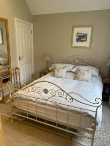 Un dormitorio con una cama blanca con almohadas. en Cosy Country Cottage, en Bethersden