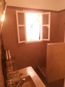 uma cozinha com um lavatório e uma janela em Maison Xanadu em Sidi Ifni