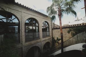 un edificio con una palmera delante de él en Hotel Boutique Patio del Posadero, en Córdoba