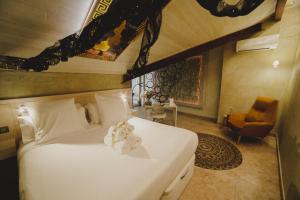 a bedroom with a bed with two stuffed animals on it at Hotel Boutique Patio del Posadero in Córdoba