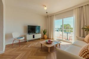 a living room with a couch and a tv at Apartamentos Top Secret Prestige Es Pujols - Formentera Vacaciones in Es Pujols