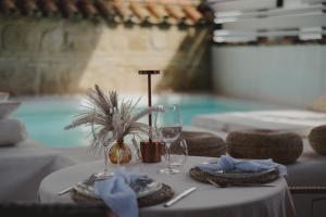 a table with a white table cloth and wine glasses at Hotel Boutique Patio del Posadero in Córdoba