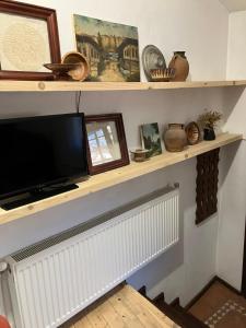 a television on a shelf above a radiator at Darina Guest house in Koprivshtitsa