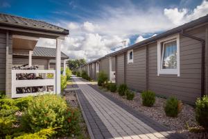 a walkway next to a row of houses at Chłopy Beach Resort in Chłopy