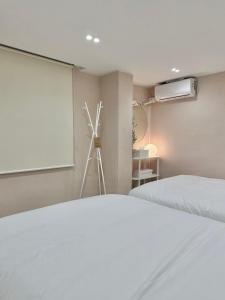een slaapkamer met een wit bed en een raam bij hoho house - double twin room in Busan