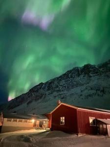 a red barn with a mountain in the background at Russelv panorama in Russelv