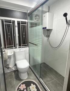 a bathroom with a toilet and a glass shower at Waveflo Hostel 浪花青旅 in Hong Kong