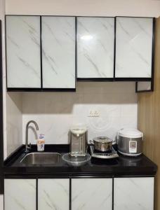 uma cozinha com um lavatório e duas panelas e frigideiras em Waveflo Hostel 浪花青旅 em Hong Kong
