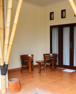 a room with two tables and chairs and bamboo poles at Vamana Bangsal in Pawenang