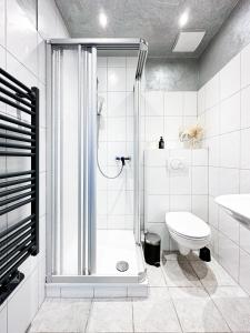 a white bathroom with a shower and a toilet at SI-View Doppelzimmer mit Stadtblick Zimmer 21 in Siegen