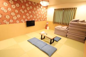 uma sala de estar com uma mesa e um sofá em KYOSTAY Iroha Komichi em Quioto
