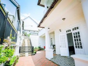 a white house with a door and a brick walkway at Villa Hằng Nga 3 in Ấp Ða Lợi