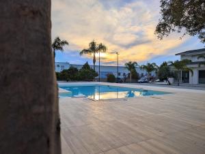 a swimming pool with a sunset in the background at Villa Dafne in Torrenova