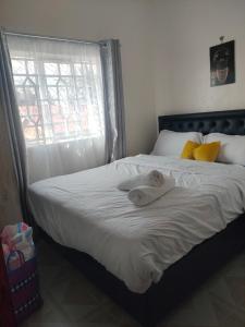 a woman laying on a bed with a towel on it at Rembeka furnished apartment in Naivasha