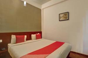 a bedroom with a large bed with red pillows at Flagship Ooty Residency in Ooty