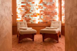 duas cadeiras num quarto com uma parede de tijolos em The Villa Suites - Pool & SPA em Como