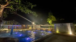 einen Hinterhofpool in der Nacht mit Pavillon in der Unterkunft TheDreamers Farm 