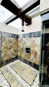 a bathroom with a stone wall with a window at Villa Love in Bel Ombre