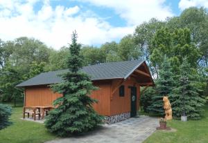 a small cabin with a picnic table and a tree at Tatralandia Chatka SnoWiki in Liptovský Mikuláš