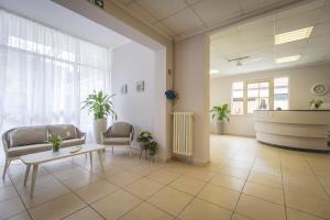 a lobby with chairs and a table in a building at Hotel La Perla in Cervia