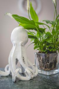 a white octopus statue sitting next to a plant at Hotel La Perla in Cervia