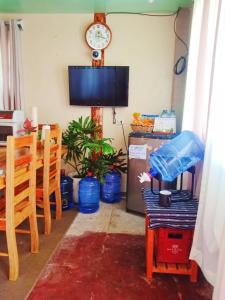 a living room with a table and a clock on the wall at Couple's Unit at BOONE'S in Sagada