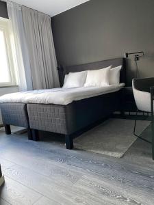 um quarto com uma cama, uma cadeira e uma janela em Hotell Iföhus em Bromölla