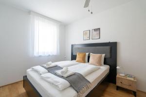 ein Schlafzimmer mit einem großen Bett mit Handtüchern darauf in der Unterkunft HM • Stylish 1BR Escape, City Quick in Wien